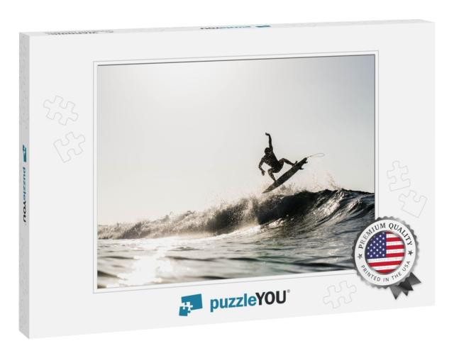 A Silhouetted Surfing Airing on a Wave Breaking on a Beac... Jigsaw Puzzle