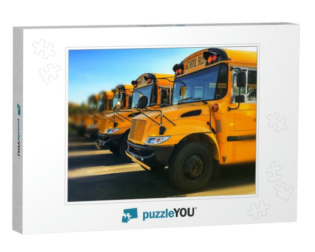 Row of Yellow School Buses Parked Inline with Blurred Bac... Jigsaw Puzzle
