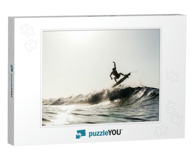 A Silhouetted Surfing Airing on a Wave Breaking on a Beac... Jigsaw Puzzle